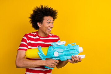 Profile photo of carefree positive person hold playing water gun look empty space isolated on...
