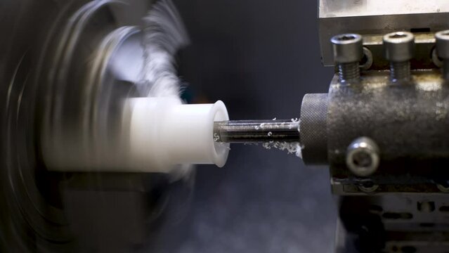 Curly cutting turning work on an automated CNC machine. Blank of textolite sleeve for processing during factory production of automated production lines.