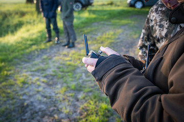 Jäger steuert die Fernbedienung einer Drohne, um Kitze vor dem Mähtod auf zu spühren - Kitzrettung.
