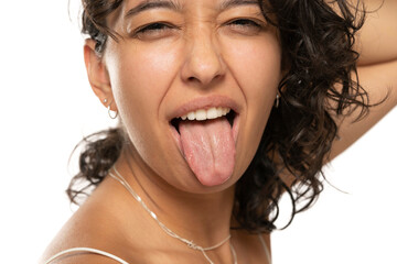 Portrait close up of young etnic woman with tongue out on a white background