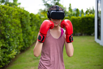 Virtual Metaverse. Young asian woman playing boxing game and workout in VR Headset.