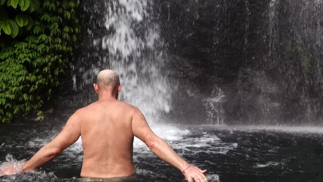 Banyumala waterfall, Bali, Indonesia A man bathes in the waterfall.
