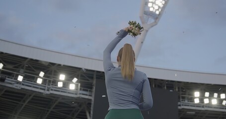 Young Female Athlete Celebrates a Win on a podium, receives a gold medal