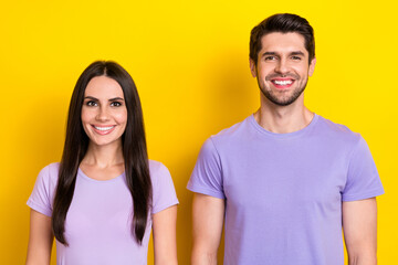 Portrait of two friendly cheerful people beaming smile have good mood isolated on yellow color background