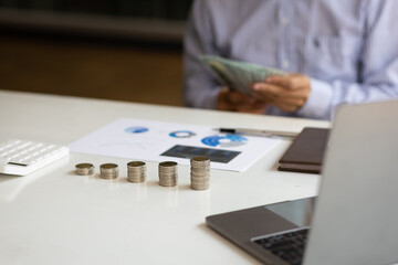 Growth investment and financial planning. Businessman counting banknotes by taking notes profit from doing business, saving money for the future and life after retirement.