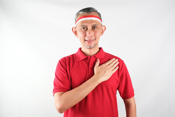 Portrait of Asian Man wearing red and white Indonesia flag attribute. Independence day concept.
