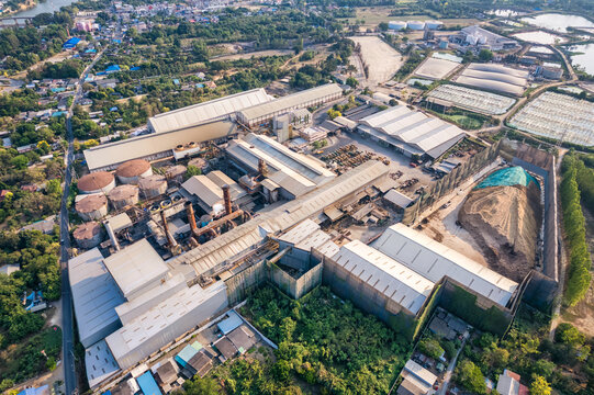Sugar cane biomass processing plant with warehouse, tank and harvester truck in factory