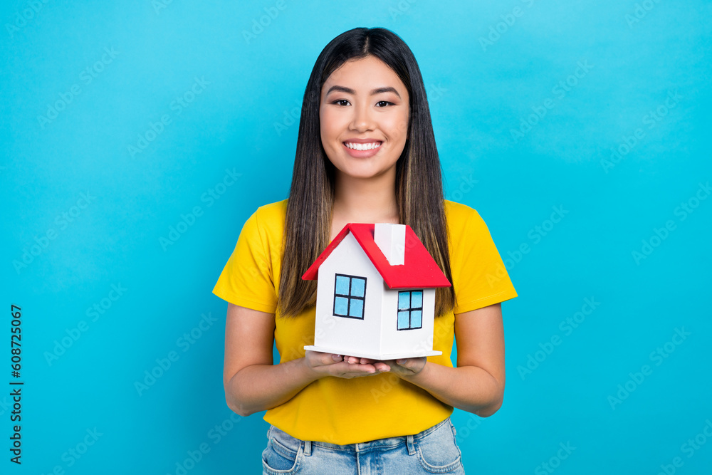 Sticker Photo of vietnamese young lady hold her new house buy insurance for rent apartment safe credit money isolated on blue color background