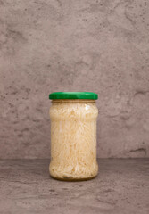 Celery Root Salad Preserve In Glass Jar With Screw Metal Cap On Shelf. Shredded And Pickled Celery Crops, Tuber. Apium Graveolens, Culinary. Vitamins C, K, A, E, PP, B. Copy Space, Vertical Plane
