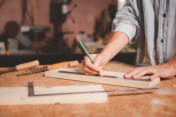 Female hands using a try square to check that the woodworking corners are square with a set collection of working hand tools for the wooden, Toolset with the do it yourself (DIY)in wood studio