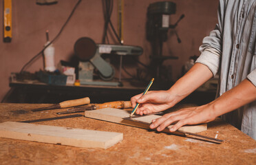 Female hands using a try square to check that the woodworking corners are square with a set collection of working hand tools for the wooden, Toolset with the do it yourself (DIY)in wood studio