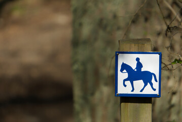 a small sign in woods riding path