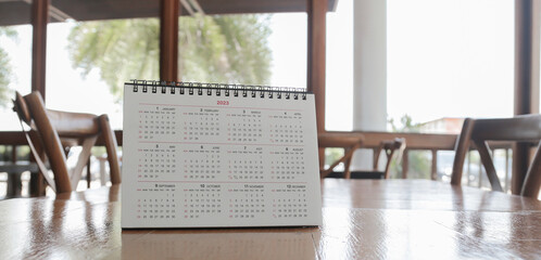 White calendar on brown wooden table