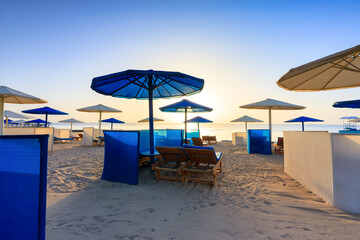 Sun loungers with umbrellas on the beach in Marsa Alam at sunrise, Egypt