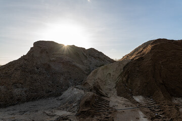 Mountain landscape/ gravel pit.. Sand, rocks and sun at sunset time.