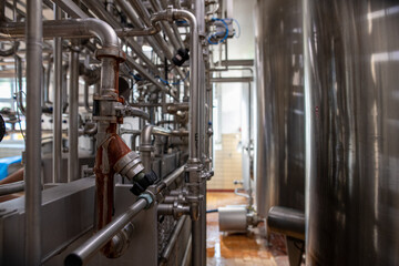 Interior of a modern manufacture with stainless steel tanks and pipes.