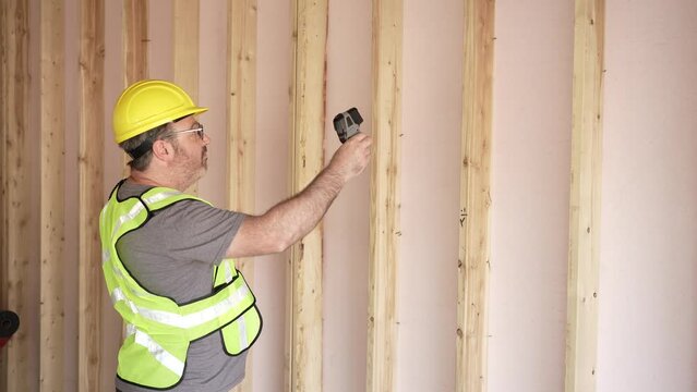 Infrared Thermometer Being Used By Construction Worker Home Builder