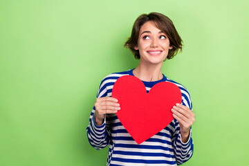 Photo of pleasant cheerful woman bob hairstyle sailor shirt look empty space holding red heart...