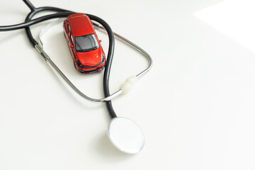 Toy car and stethoscope on white background