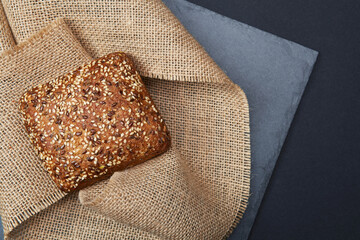 One freshly baked rustic square shaped bread loaf with sesame seeds on the vintage rustic country...