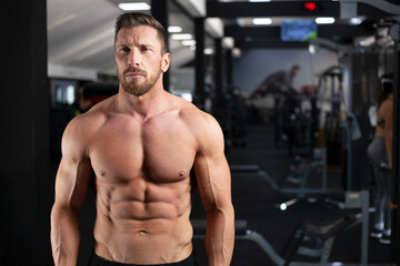 Obraz na płótnie Canvas Strong sexy muscular bodybuilder guy in a gym. Concept gym, crossfit, bodybuilding.