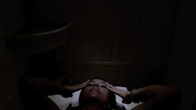Woman Relax in a Dark Turkish Hammam Bathroom in Switzerland.