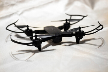 Black drone with rotating propellers isolated on white background	
