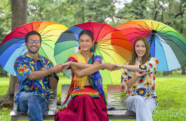 lgbt friends in colorful rainbow dresses,diverse genders people having fun in the park,young...
