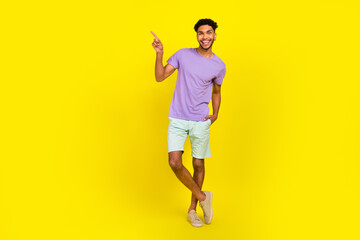 Fototapeta na wymiar Full length photo of young guy outfit clothes wear purple t-shirt blue shirts direct finger mockup price list isolated on yellow background