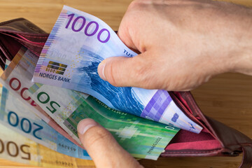 Taking money out of wallet, Norwegian crowns, Financial and economic concept, Household situation,...