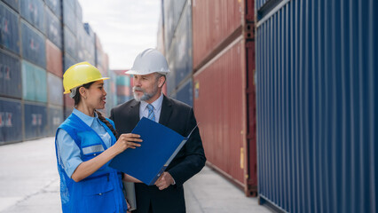 Businessman,  Engineer or foreman talking and checking inventory or task details at container yard warehouse., Logistics concept inside the shipping, import, and export industries.