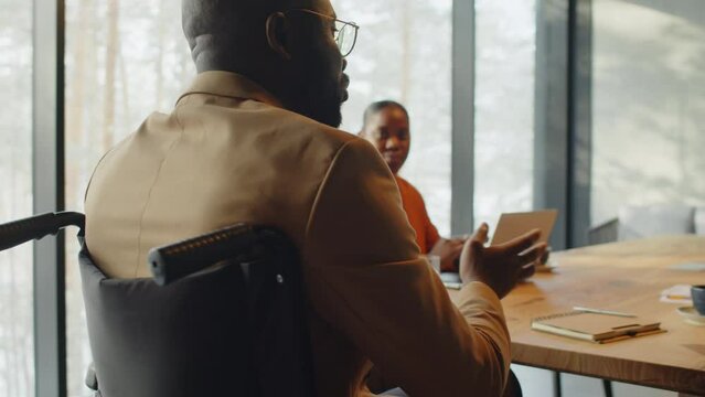 Businesswomen and businessman in wheelchair having a meeting