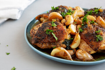 Homemade Chicken With 40 Cloves of Garlic on a Plate, side view. Close-up.