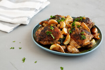 Homemade Chicken With 40 Cloves of Garlic on a Plate, side view. Close-up.