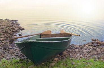 rowboat or row boat in a tranquil summer landscape shore with calm water