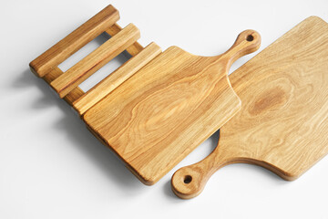Two homemade wooden cutting boards with round handles and a stand on a white background. Daylight