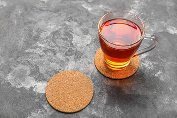 Drink coasters with cup of tea on grey grunge table