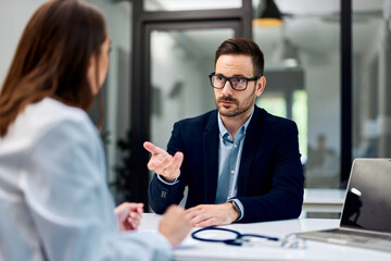 A man talking with a female doctor about his health condition, elegantly dressed.