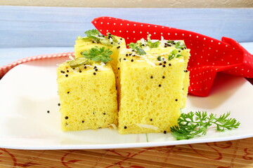 traditional indian gujarati snack khaman dhokla fast food dish made from chana dal,closeup,top view with selective focus