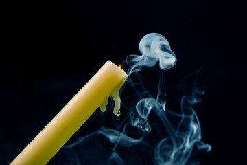 Smoke from an extinguished candle on a dark background. The concept of spirituality and the end of...