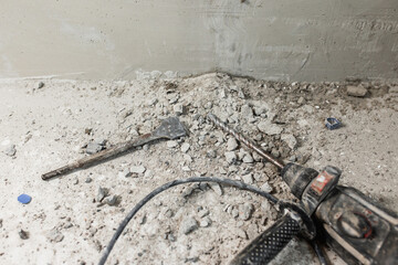 Electric professional hammer drill on the floor at the place of chasing - a drill bit and a chisel...