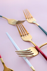 Golden forks on pink background