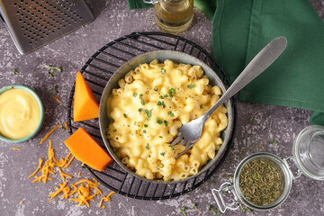 Bowl of tasty Italian pasta with Cheddar cheese on grunge background