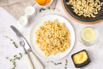 Plate of tasty Italian pasta with Cheddar cheese on light background