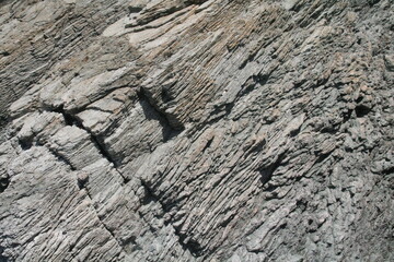Natural coastal rock formation surface rough material close up textured wall pattern background cracked grunge cliff surface 