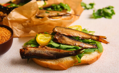 Tasty sandwiches with canned smoked sprats on white background