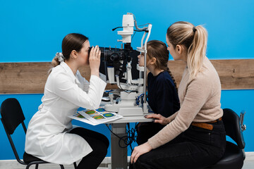 Slit lamp diagnosis and examination of the cornea and eyes of child girl. Pediatric ophthalmologist...