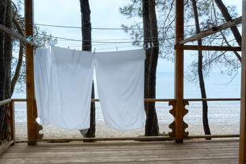 Drying clothes outdoors by the sea. Veranda with wooden floors overlooking the sea.