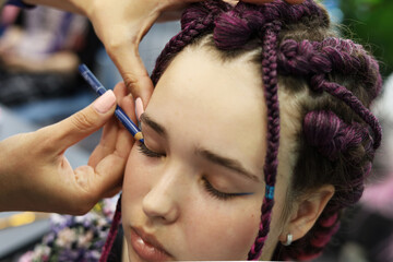 a girl with brown hair and pigtails braided into a pigtail of artificial hair. The process of...