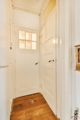 the inside of a room with wood flooring and white door leading to an open doorway that leads to another room